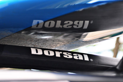 Cyan Hecuba DORSAL Aero Rack Pads on 34-inch car crossbars holding a surfboard, kayak, and SUP for roof transport.