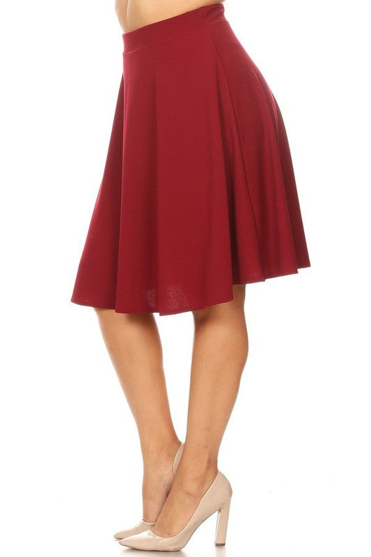 Solid high-waisted A-line knee-length skirt by Jade Icarus, shown in a natural pose on a woman, highlighting its fit and style.