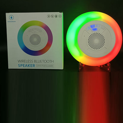 Salmon Lucky Floatilla Bluetooth waterproof speaker with LED lights, floating in a pool, showcasing its portable poolside tech accessory