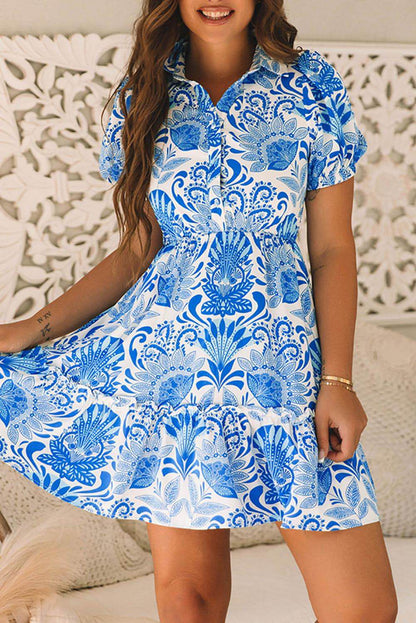 Sky blue retro floral print mini dress with ruffled details and drawstring waist by Carmine Juneberry.