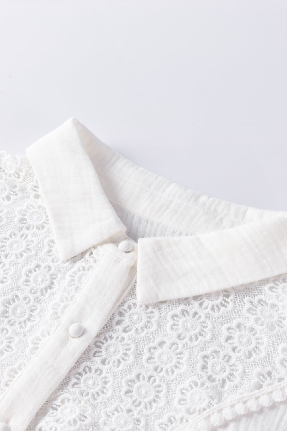White floral lace hollow-out splicing crinkled blouse by Carmine Juneberry, showcasing intricate lace details and stylish design.