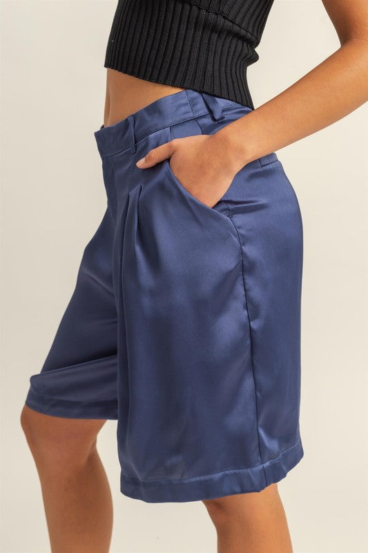 Jade Icarus HYFVE high-waist pleated satin shorts for women, featuring a shiny, smooth fabric and stylish pleated design.