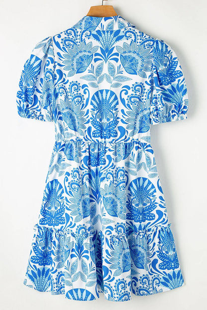 Sky blue retro floral print mini dress with drawstring waist and ruffled hem by Carmine Juneberry.