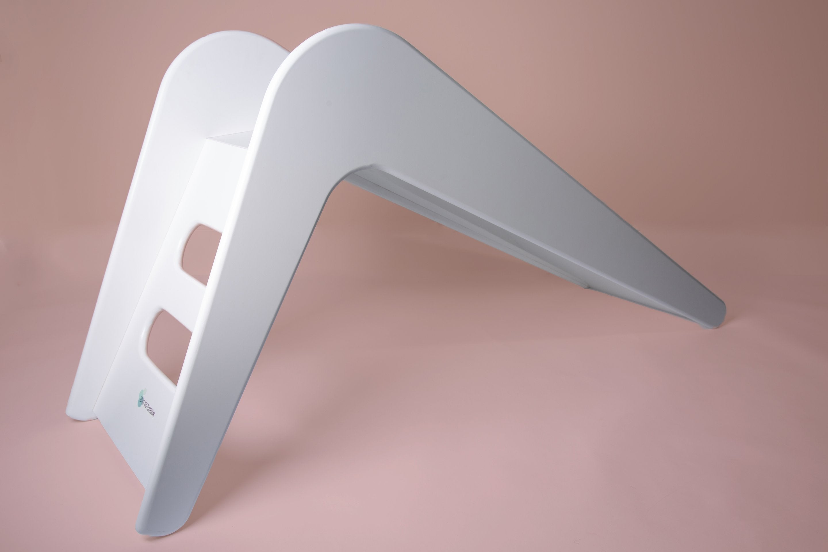 White wooden indoor slide for kids by Rose Metis, featuring a smooth finish and sturdy design for safe indoor play.