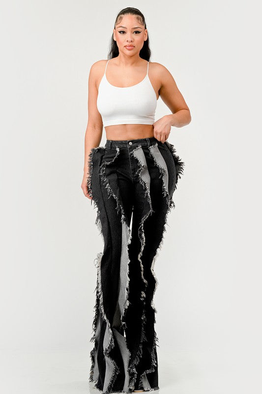 Distressed denim frill jeans by Jade Icarus featuring ripped details and ruffled accents on a casual fit.
