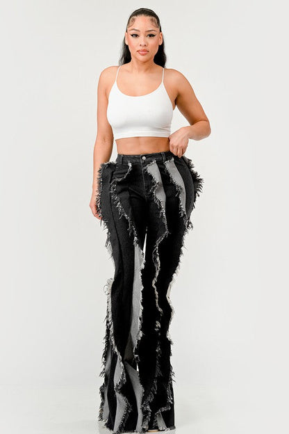 Distressed denim frill jeans by Jade Icarus featuring ripped details and ruffled accents on a casual fit.
