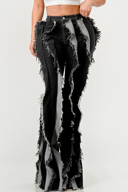 Distressed denim frill jeans by Jade Icarus featuring ripped details and ruffled hems, styled on a model.