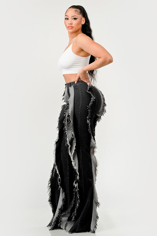 Distressed denim frill jeans by Jade Icarus featuring frayed hems, ripped details, and a relaxed fit on a model.