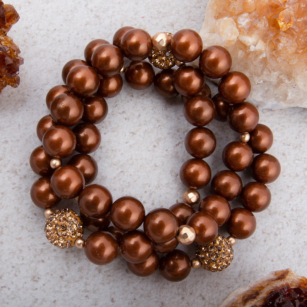 Mocha brown pearl and gold sparkle bracelet set featuring elegant jewelry pieces with shimmering accents.