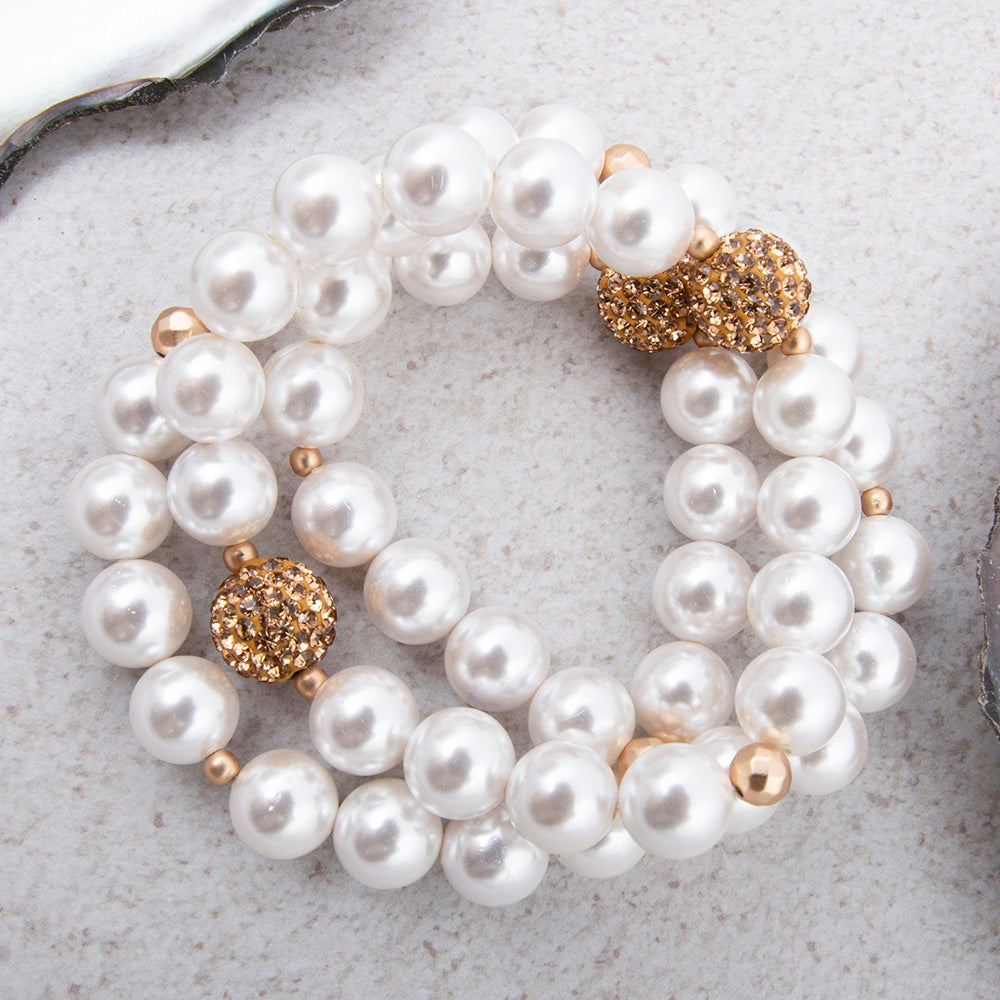 Chunky white pearl and gold bracelet set featuring three stylish bangles, perfect for elegant jewelry styling.