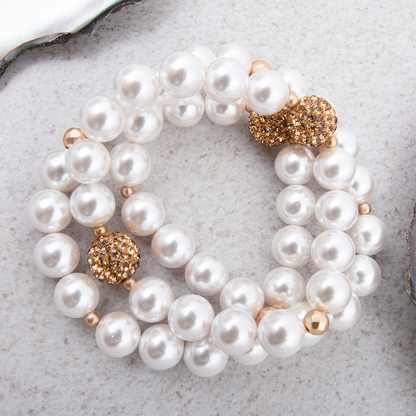 Chunky white pearl and gold bracelet set featuring three stylish bangles, perfect for elegant jewelry styling.