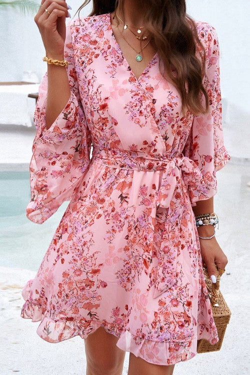 Floral wrap dress by Jade Icarus featuring long sleeves, vibrant floral pattern, and cinched waist for a stylish women&