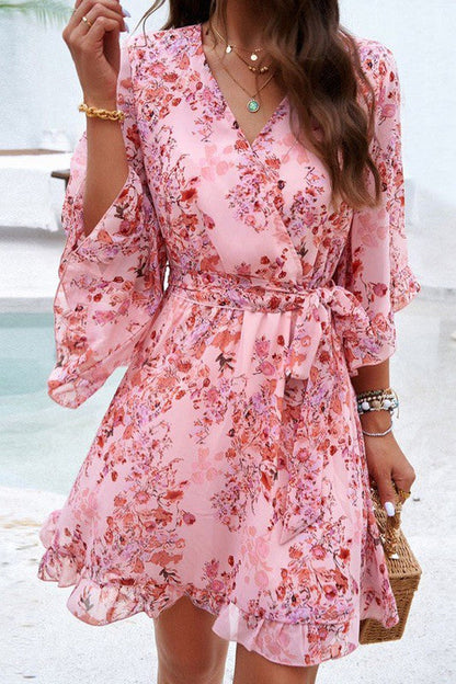 Floral wrap dress by Jade Icarus featuring long sleeves, vibrant floral pattern, and cinched waist for a stylish women&