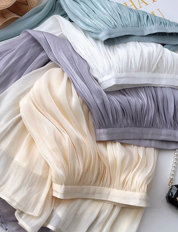 Mid-length A-line skirt by Jade Icarus in neutral fabric, styled with a high waist and flowing silhouette.