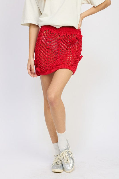 Jade Icarus crochet mini skirt with rosette detail, featuring intricate crochet pattern and decorative floral accents.