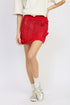 Jade Icarus crochet mini skirt with rosette detail, featuring intricate crochet pattern and decorative floral accents.