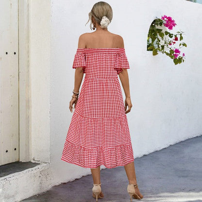 Summer plaid dress for women with puff sleeves, made by Jade Icarus, displayed on a hanger with a casual outdoor background.