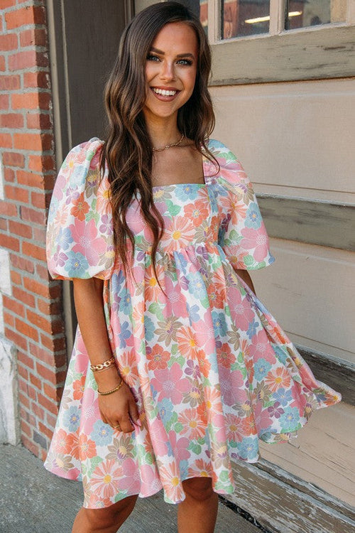 Women’s square neck puff sleeve babydoll dress by Jade Icarus, displayed in a fashion photo with a focus on the dress details.