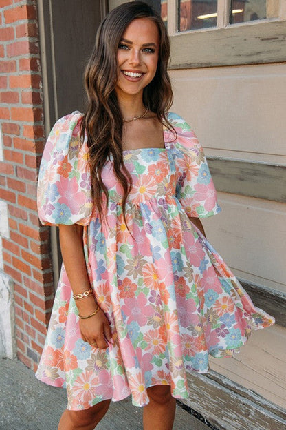 Women’s square neck puff sleeve babydoll dress by Jade Icarus, displayed in a fashion photo with a focus on the dress details.