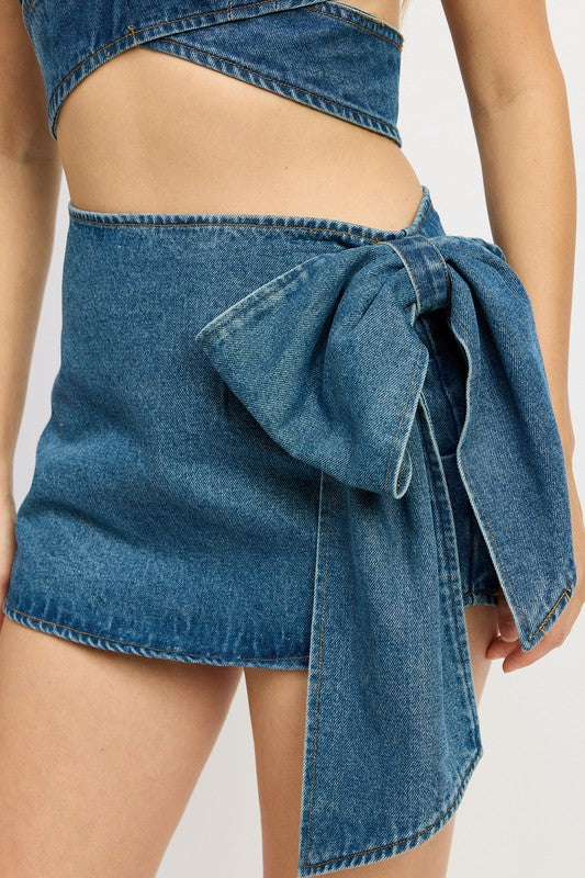 Women’s denim mini skirt with bow detail by Jade Icarus, showcasing the stylish front view and classic denim texture.