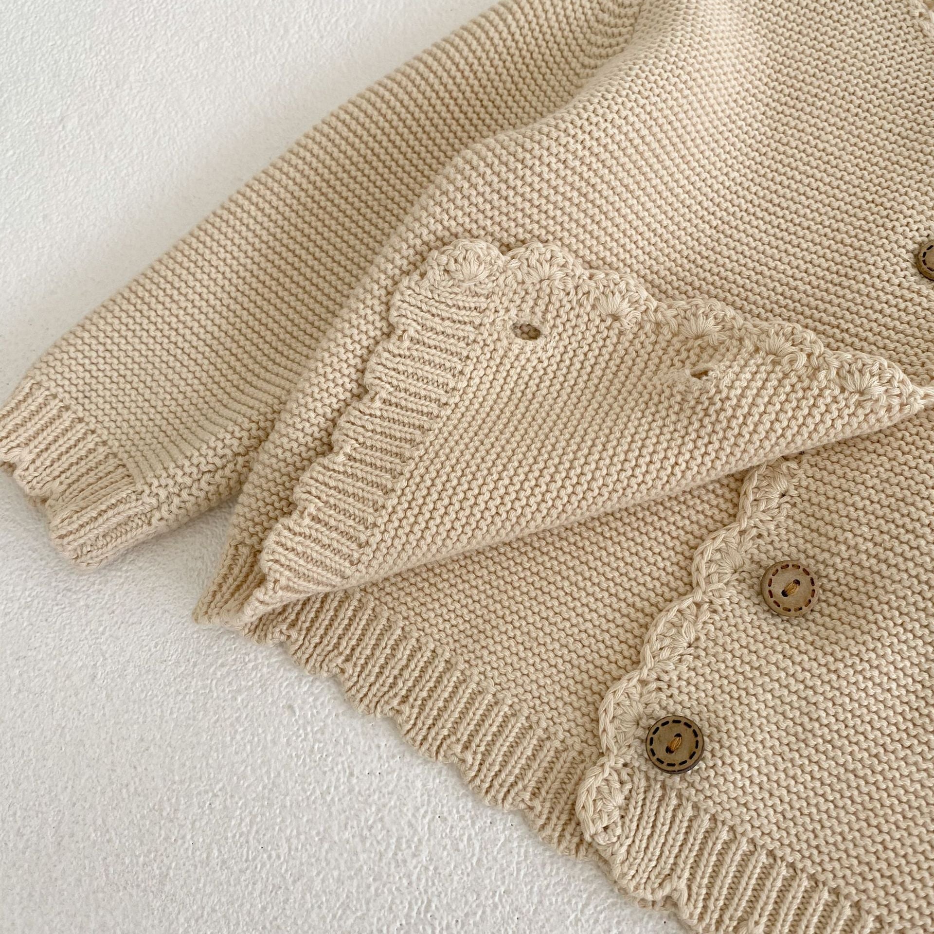 Baby unisex solid color crochet cardigan by Yellow Angel, soft knit sweater for kids and babies, close-up of front detail.