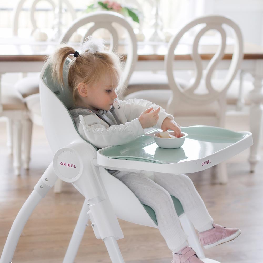 Ultramarine Dione Oribel Cocoon baby high chair with cushioned seat and safety harness for infant toddler feeding.