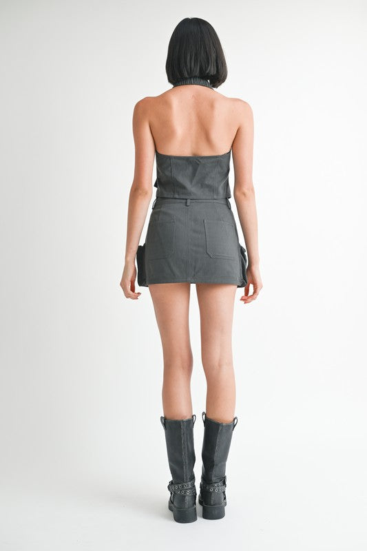 Jade Icarus exposed cargo pocket mini skirt with automotive-inspired design, featuring visible pockets and rugged fabric.