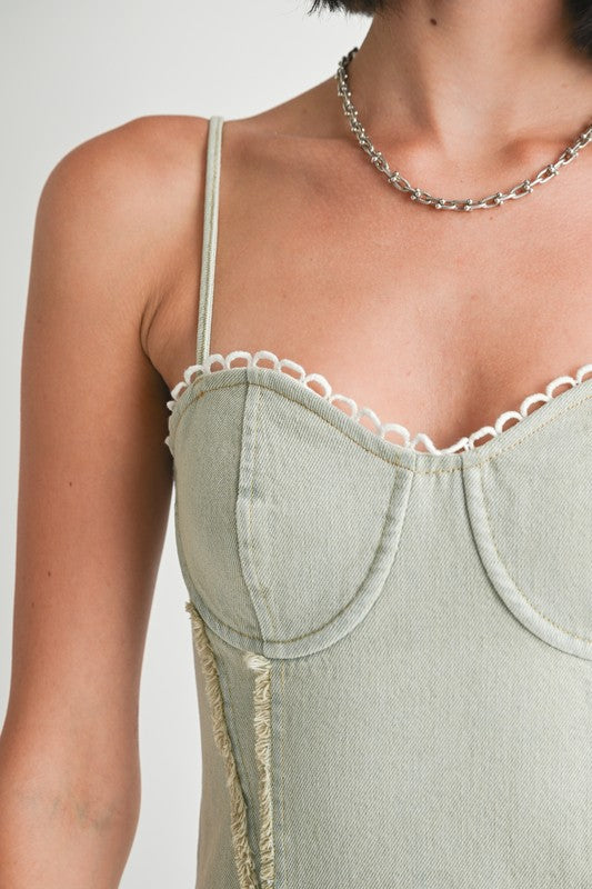 Mini sleeveless denim dress by Jade Icarus, featuring a casual fit with front pockets and adjustable straps.