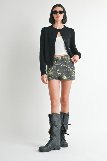 Automotive wrapped mini skirt with button details by Jade Icarus, featuring stylish fabric and decorative button accents.
