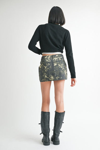 Automotive wrapped mini skirt with button details from Jade Icarus, featuring a stylish, fitted design and decorative buttons.