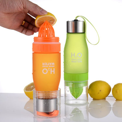 Fuchsia Molly lemon fruit juicer bottle in a kitchen setting showing the bottle with lemon juice and lemon slices inside.