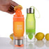 Fuchsia Molly lemon fruit juicer bottle in a kitchen setting showing the bottle with lemon juice and lemon slices inside.