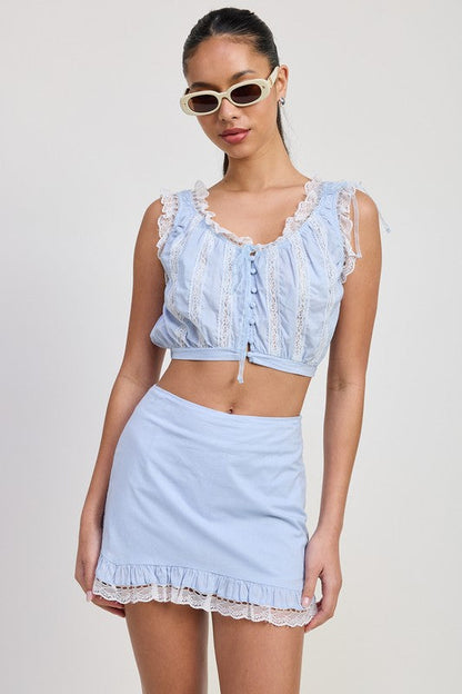 Automotive ruffled mini skirt with lace detail by Jade Icarus, featuring intricate lace accents and ruffled fabric on the mini skirt.