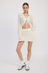 Jade Icarus lettuce hem mini crochet skirt displayed on a model, showcasing its textured crochet fabric and stylish hem detail.