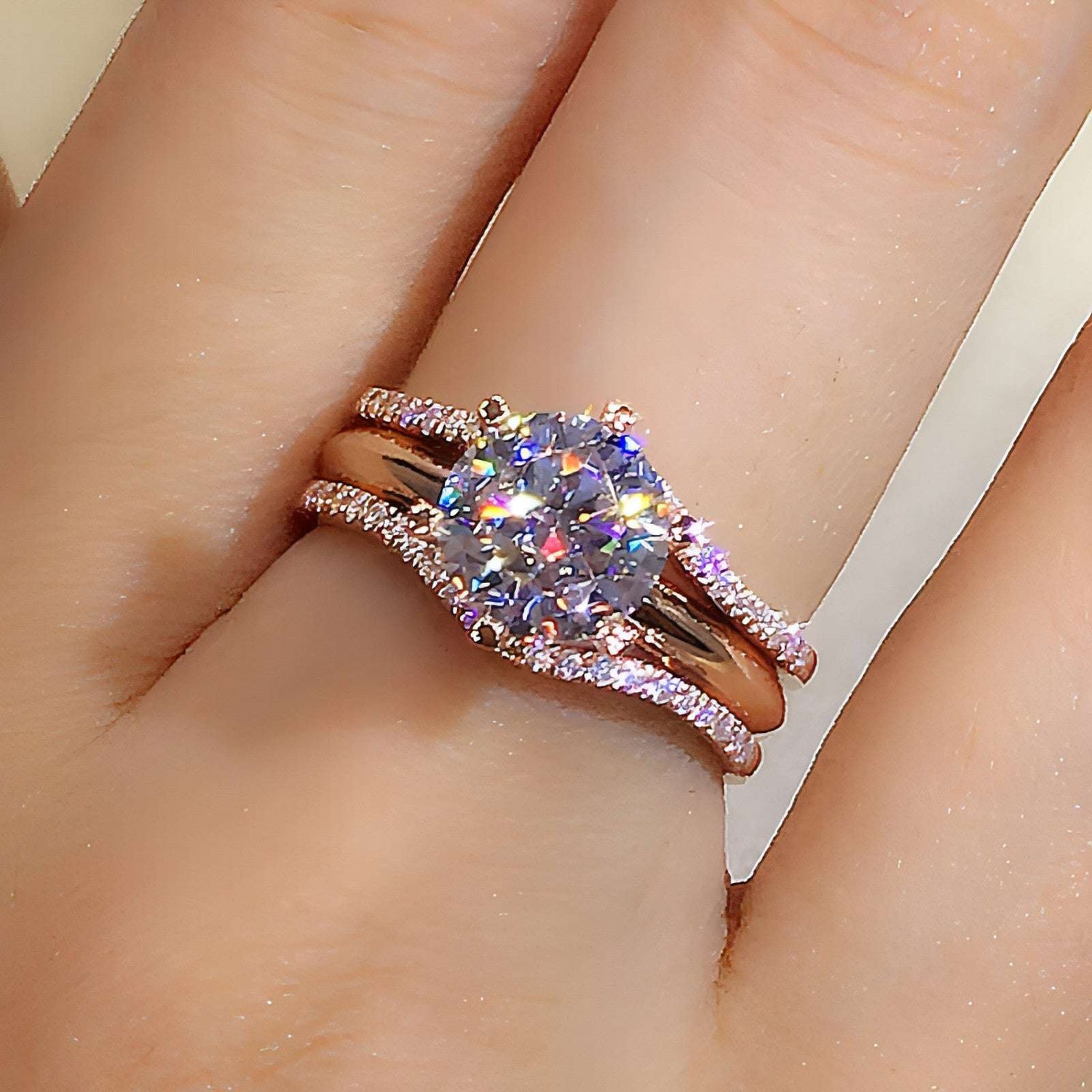 Pair of 18K gold moissanite rings from Carmine Juneberry featuring sleek, elegant designs on a white background.