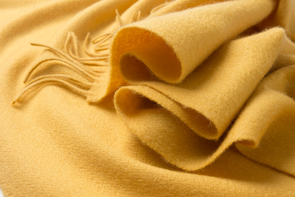 Yellow woven lambswool scarf from Start2Finish with a plain design, soft texture, and fringed edges.
