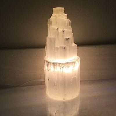 Small Teal Lily Selenite Skyscraper Lamp for home decor, featuring a clear, layered selenite crystal design with a warm glow.