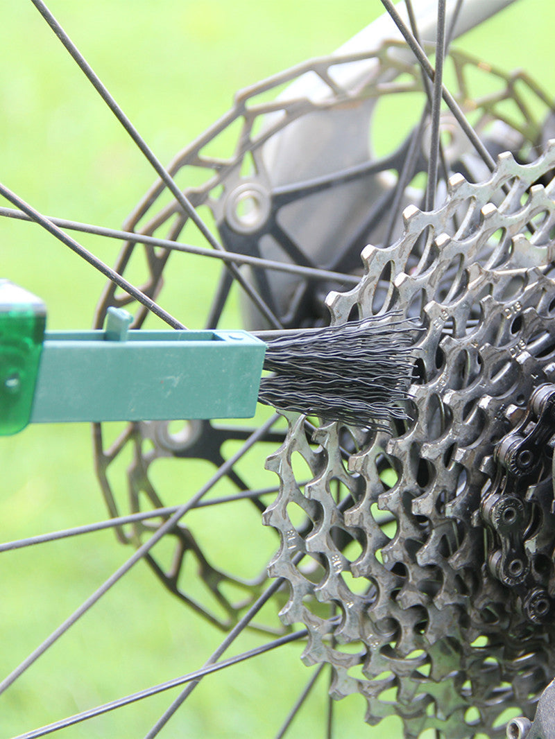Maroon Asteria bicycle chain cleaner scrubber brush kit for cycling maintenance, shown in a close-up image.