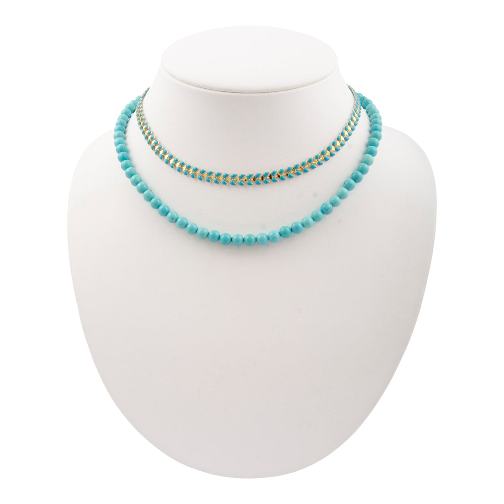 Blue turquoise magnesite layers with golden chevron necklace, jewelry piece featuring vibrant stones and elegant design.