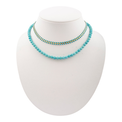 Blue turquoise magnesite layers with golden chevron necklace, jewelry piece featuring vibrant stones and elegant design.