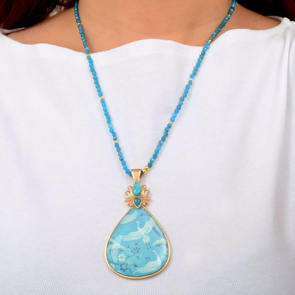 Start2Finish Heron Flight Blue Teal Apatite pendant necklace featuring a golden chain and a detailed heron bird design.