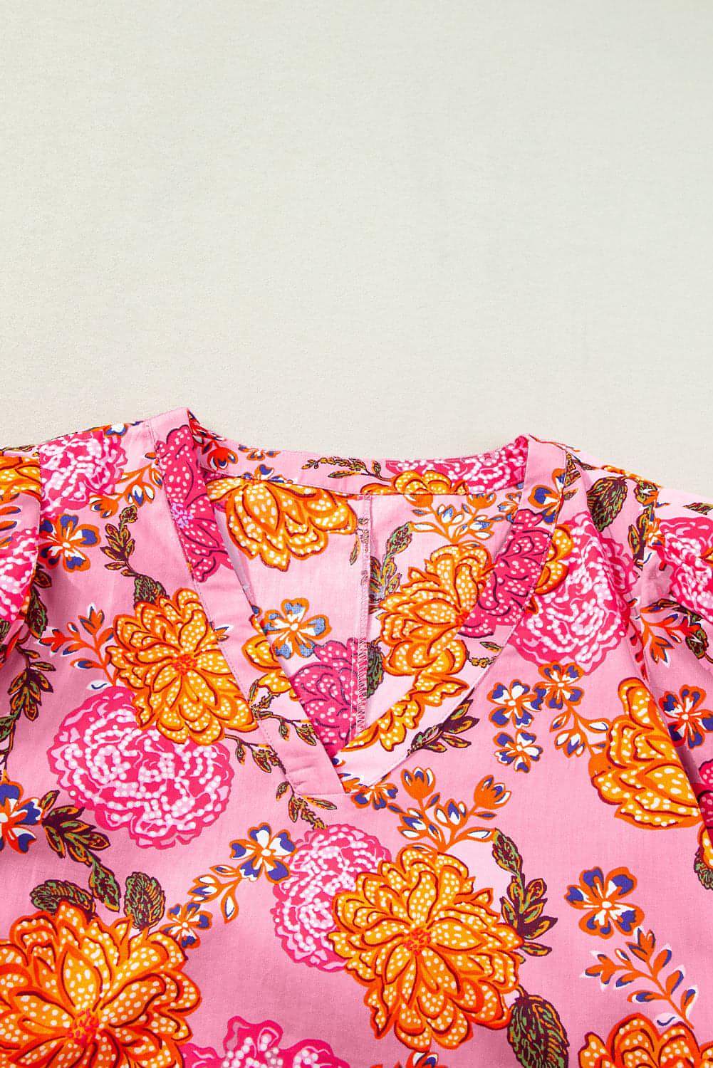 Pink floral bubble sleeve V-neck ruffled mini dress by Carmine Juneberry, featuring a feminine design with floral patterns and ruffle details.