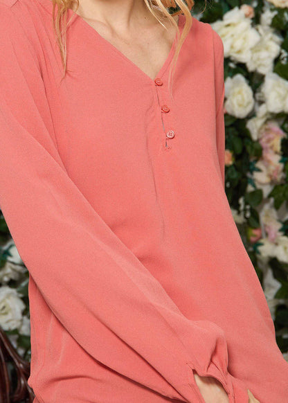 Lemon Hera V-neck tie cuff blouse in faded coral, featuring a fitted design with long sleeves and elegant detailing.