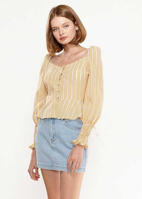 Yellow Lemon Hera smocked cuff button front peplum blouse with long sleeves and ruffled details, styled as a fashionable women&