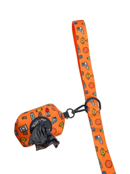 Carmine Phanes Got Game? basketball-shaped poop bag holder with leash attachment, designed for pet accessories and outdoor walks.