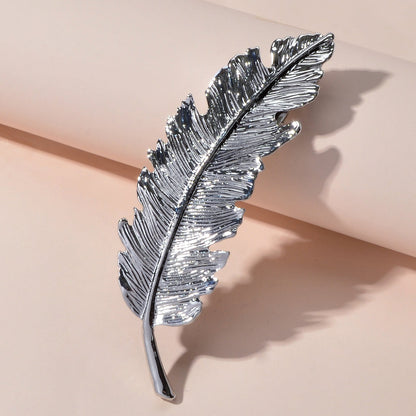 Gold and silver feather metal hair clips by White Demeter, stylish hair accessories for elegant hairstyles.