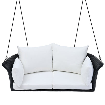 Black wicker hanging rattan porch swing for 2, Carmine Juneberry garden furniture, with white cushions, suitable for outdoor relaxation.
