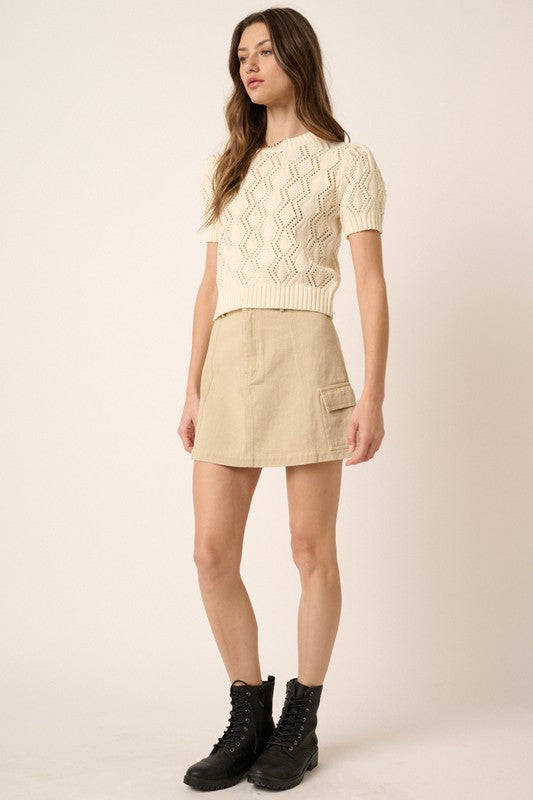 Jade Icarus Mittoshop Cargo Mini Skirt with side pockets, stylish automotive-inspired design, shown with a casual urban outfit.