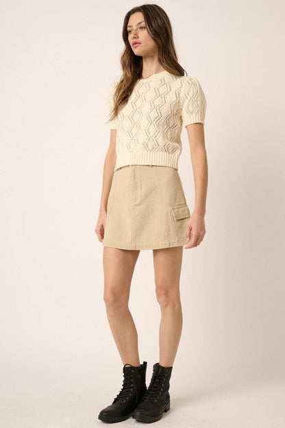 Jade Icarus Mittoshop Cargo Mini Skirt with side pockets, stylish automotive-inspired design, shown with a casual urban outfit.