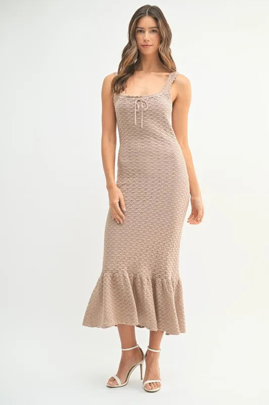 Pear Daisy ruffled hem sleeveless crochet knit midi dress in a home and garden setting, showcasing the stylish design and fabric details.